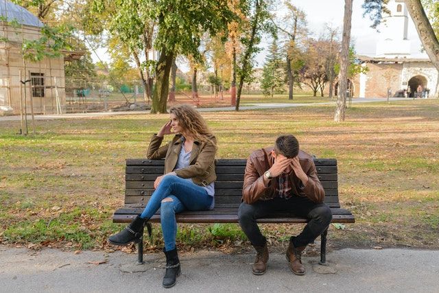 woman-and-man-sitting-on-brown-wooden-bench-small