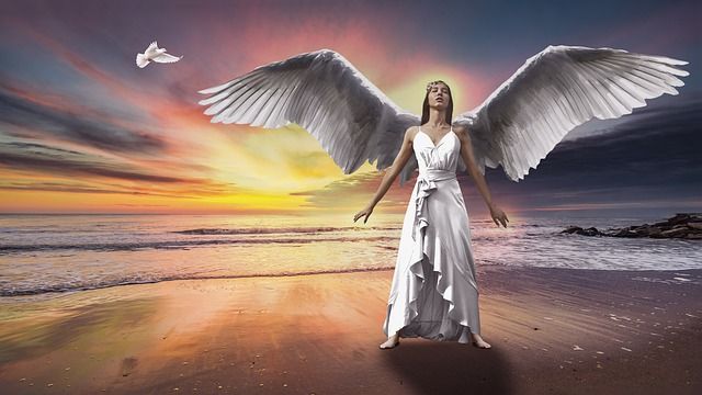 angel-woman-in-white-dress-spreading-wings-on-a-beach-with-sunset