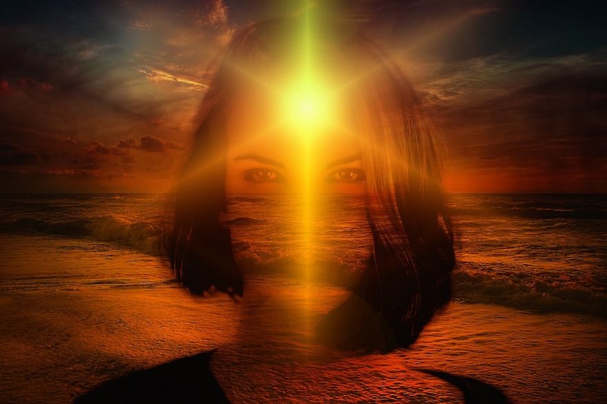 Shadowed fantasy image of a woman looking in the face at sunset on a beach, a sunlight illuminates her face from behind